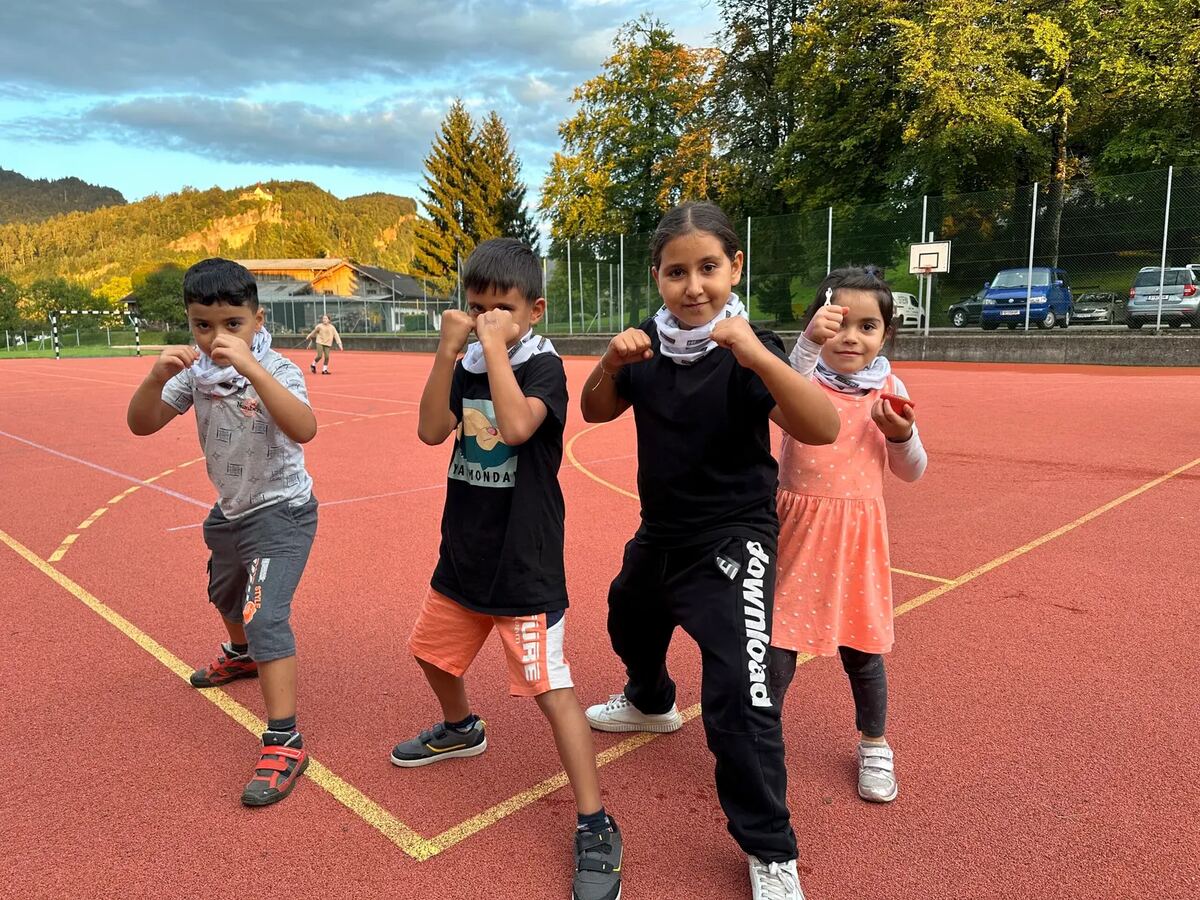 Kinder in Kampfstellung auf dem Sportplatz in der Abenddämmerung