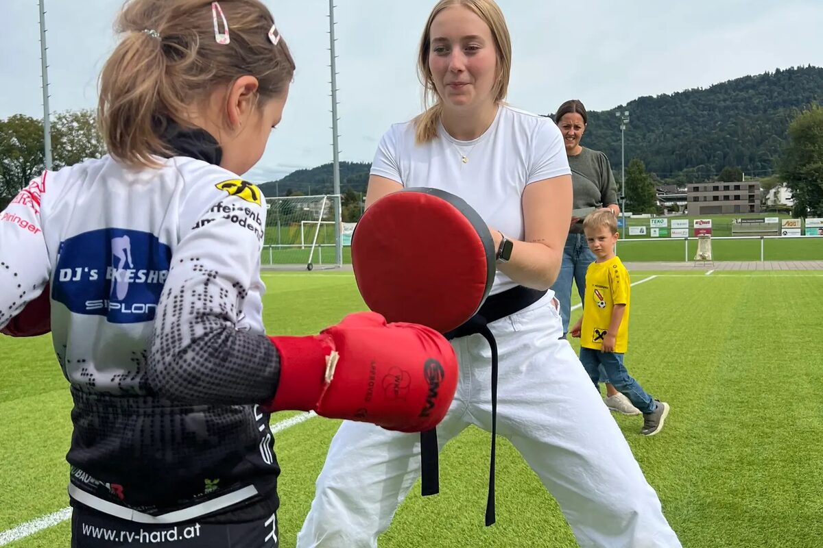 Kind schlägt auf ein Schlagpolster, Trainerin hält dagegen