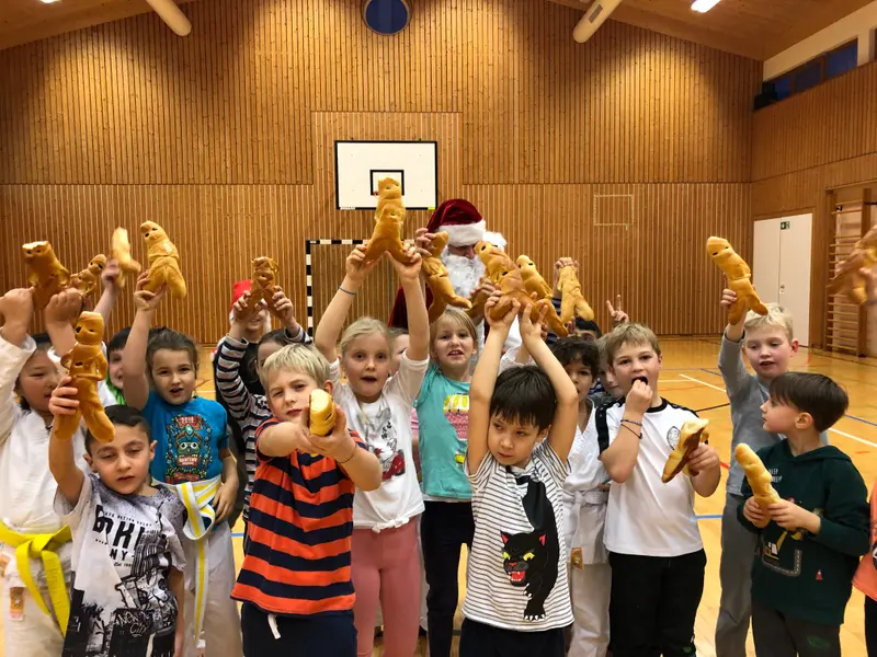 Gruppe von Kindern hält Gebäckfiguren in die Höhe