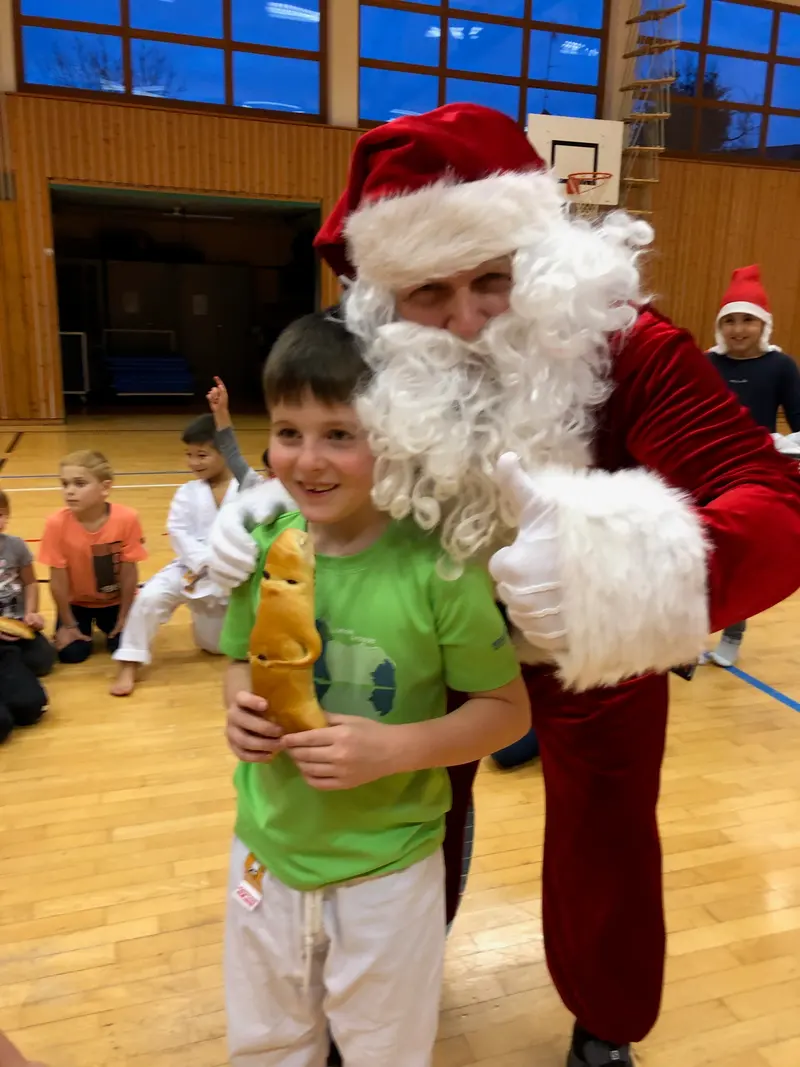 Nikolaus sitzt neben einem Kind mit Gebäckfigur