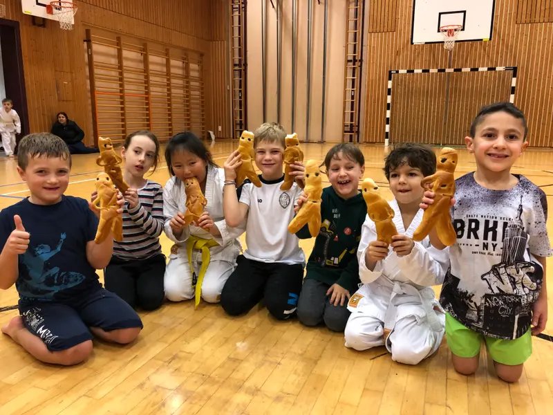 Gruppe von Kindern kniet mit Gebäckfiguren auf dem Boden