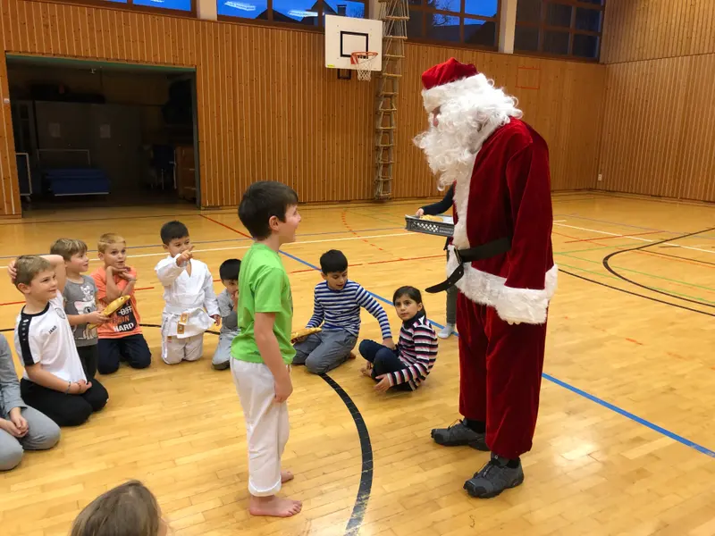 Kinder sitzen im Kreis um den Nikolaus