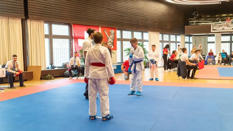 Zwei Kinder mit Boxhandschuhen stehen sich im Kumite gegenüber