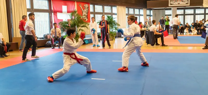Zwei Jugendliche im Kumite-Kampf mit roten Fußschützern