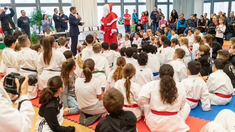 Kinder sitzen im Kreis vor einer Person im Nikolauskostüm