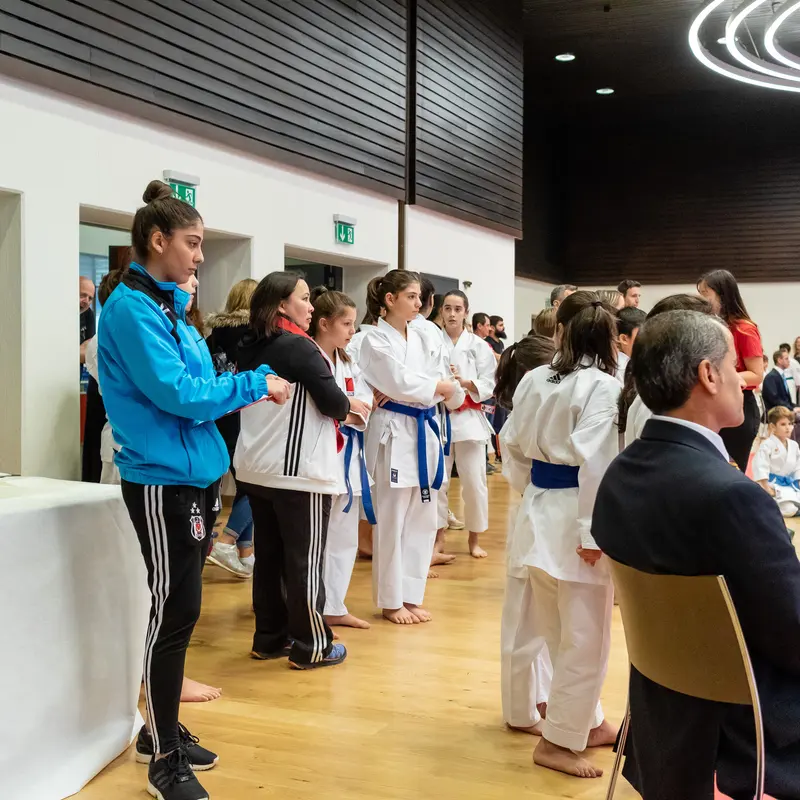 Trainer überreicht Kind im Karategi eine Medaille