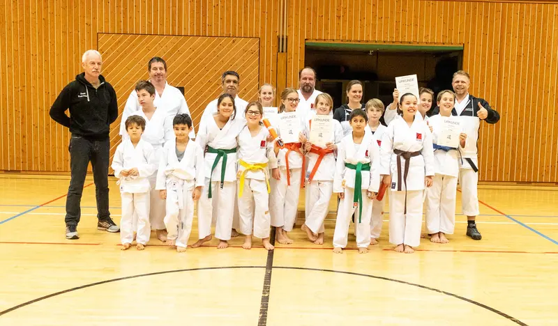 Gruppe von Kindern und Trainern posiert für ein Gruppenfoto