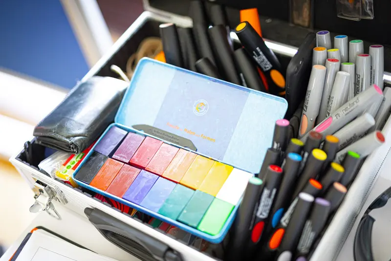 Zeichenkoffer mit Filzstiften und Aquarellfarben in Nahaufnahme.