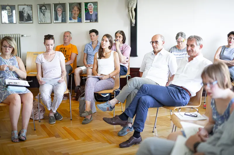 Kleine Gruppe sitzt im Kreis und unterhält sich.