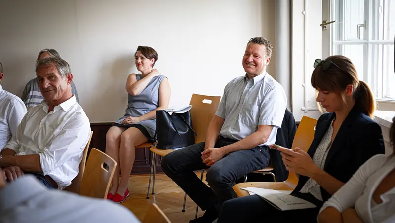 Vier Personen sitzen im Kreis und unterhalten sich.