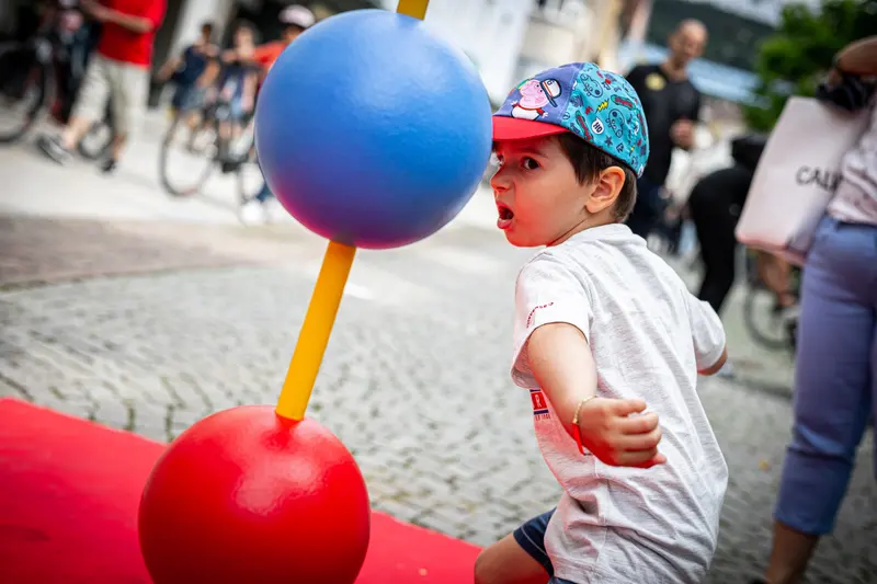 Kind weicht blauem und rotem Reflexball an Stange aus