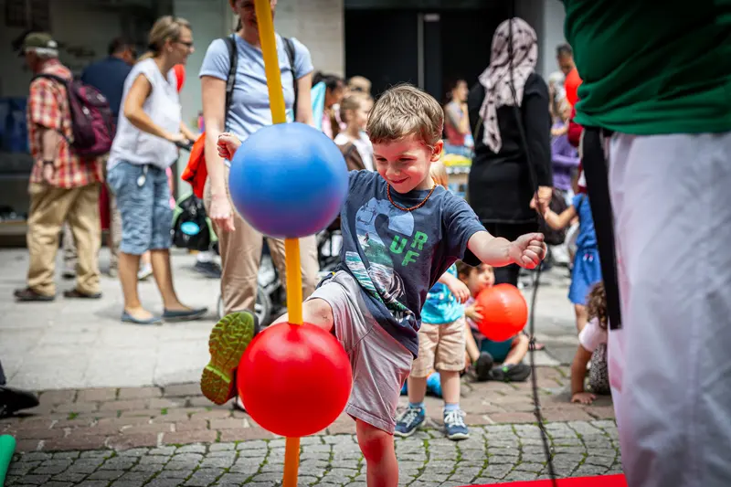 Kind tritt gegen roten Reflexball an Stange