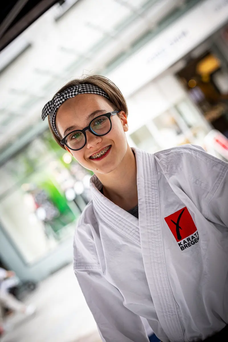 Porträt einer Person mit Zopf und Brille im Karategi