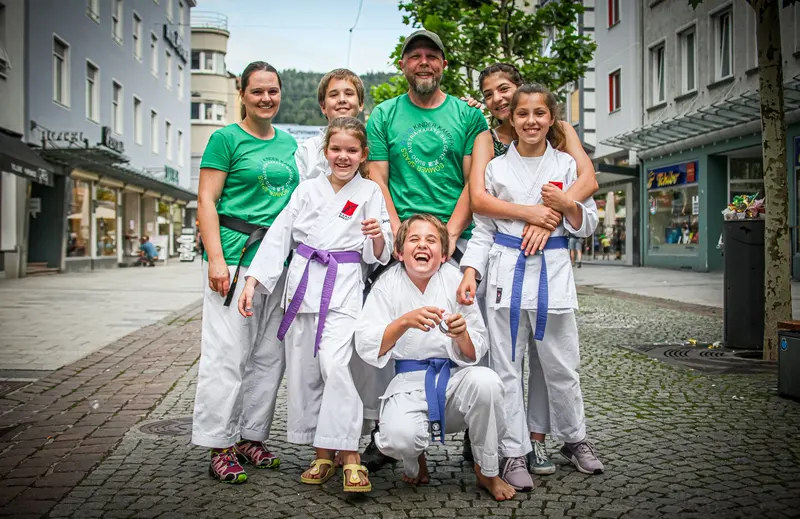 Gruppenfoto von Trainern und Kindern in Karategi in der Fußgängerzone