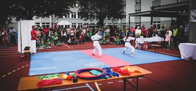 Kind balanciert über eine Bank neben Spielgeräten