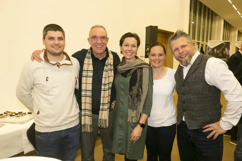 Fünf Personen stehen lächelnd nebeneinander im Foyer