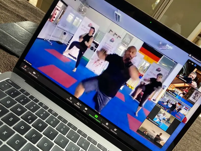 Person spricht in Kamera während Videokonferenz mit vielen Teilnehmenden