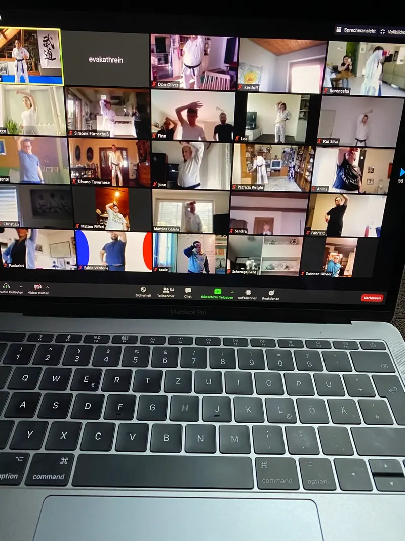 Laptop-Tastatur mit Videokonferenz-Kacheln auf dem Bildschirm