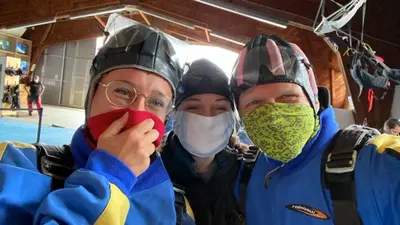 Drei Personen mit Sturmhauben und Masken posieren für ein Foto