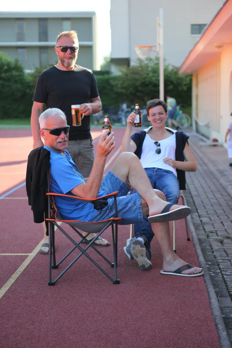 Zwei Personen sitzen mit Getränken auf Campingstühlen