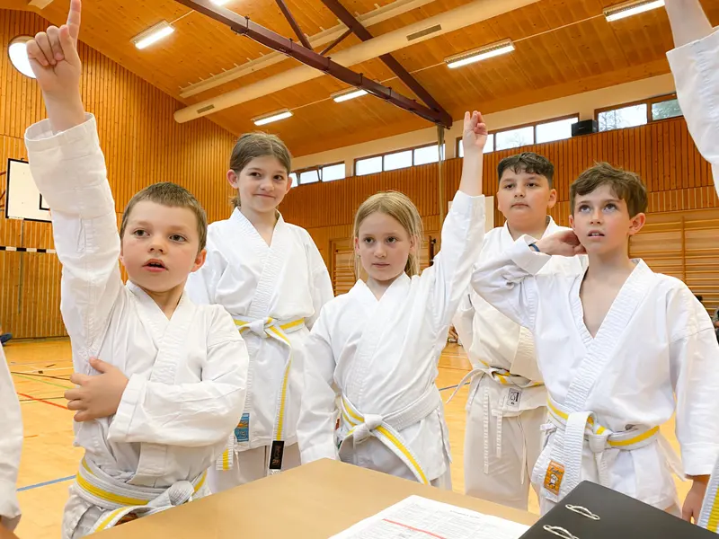 Gruppe von Kindern jubelt mit erhobenen Armen