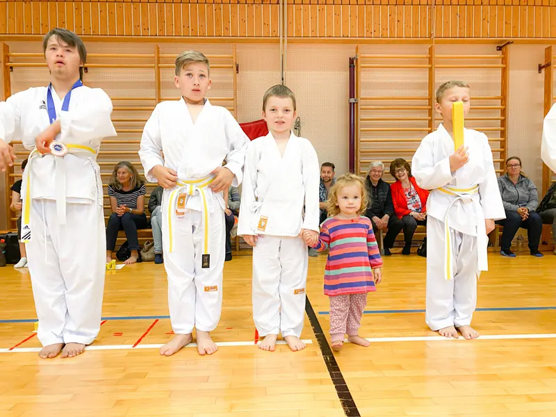 Drei Kinder mit Urkunden stehen nebeneinander