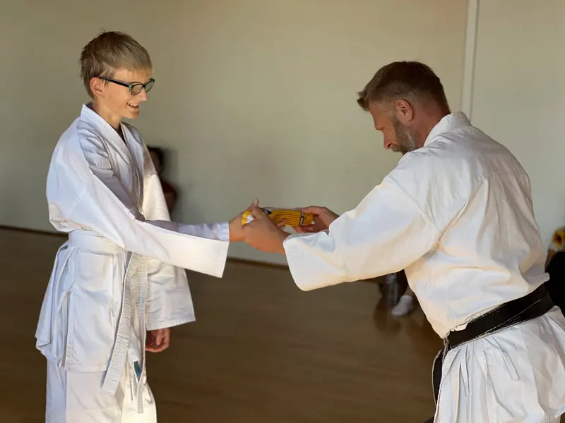 Kind und Prüfer beim Handschlag