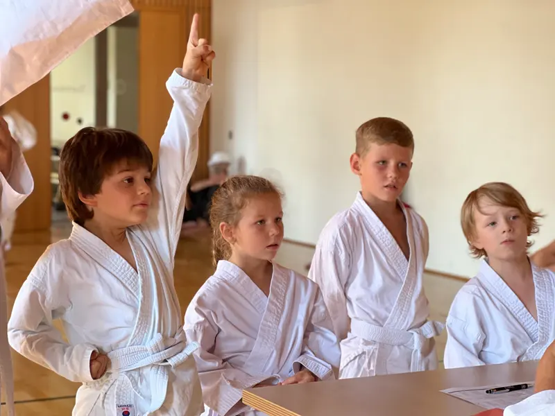 Gruppe Kinder steht zusammen, eines zeigt nach oben