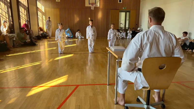 Zwei Kinder stehen mit Abstand in der Halle