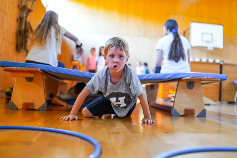Kinder klettern und spielen auf Turngeräten in der Halle