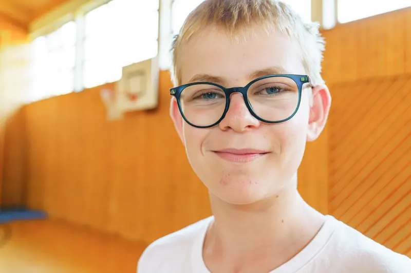 Kind mit Brille lächelt in die Kamera, Porträt