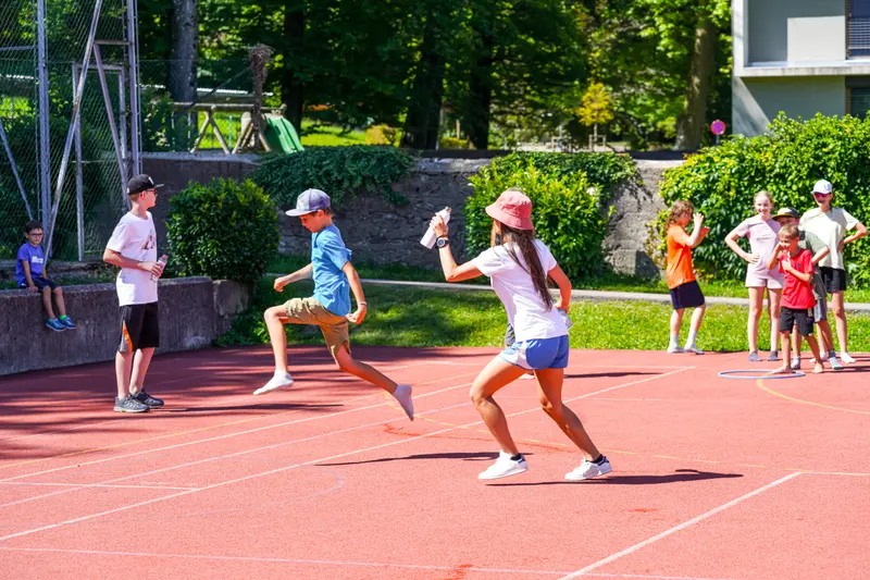 Kinder laufen um die Wette auf roter Laufbahn