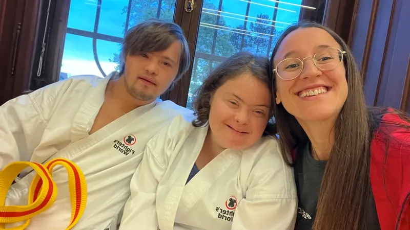 Zwei Personen im Karategi lächeln gemeinsam in die Kamera, Selfie