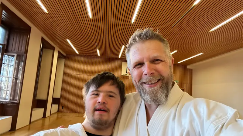 Zwei Personen in Karategi posieren nah beieinander für ein Foto