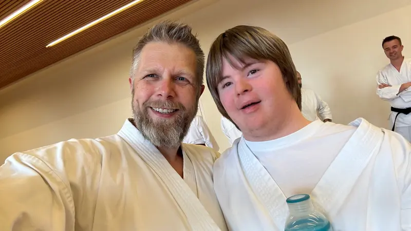 Zwei Personen in Karategi lächeln für ein Nahaufnahmefoto