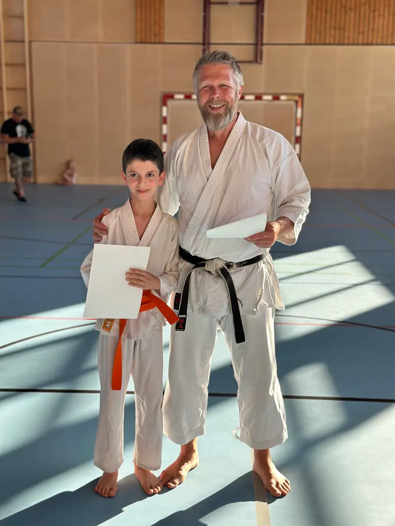 Prüfer legt Arm um Kind, das ein Blatt in der Hand hält