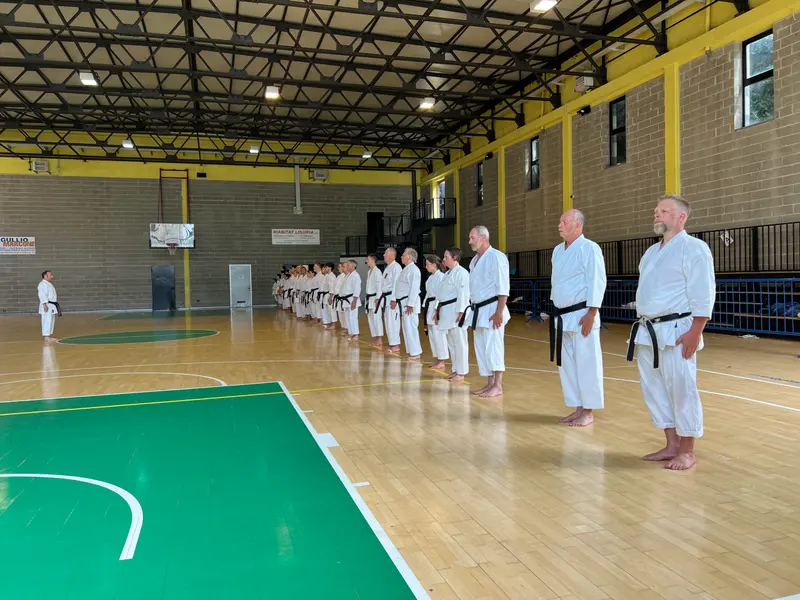 Gruppe steht aufgereiht in einer großen Sporthalle