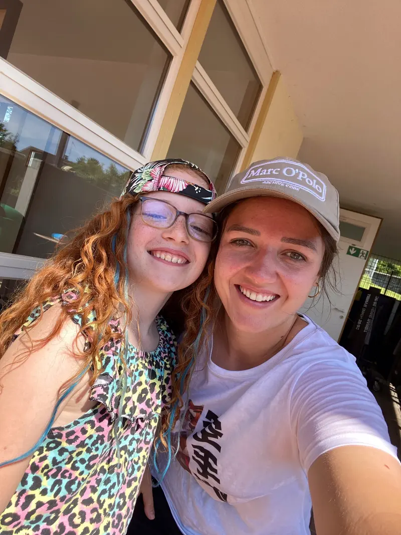 Zwei Personen mit Kappen posieren lächelnd für ein Selfie