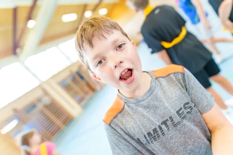 Kind ruft mit offenem Mund in einer Turnhalle