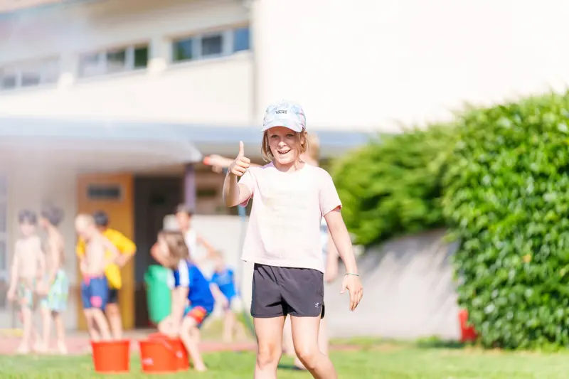 Kind läuft mit erhobenem Arm, im Hintergrund weitere Kinder