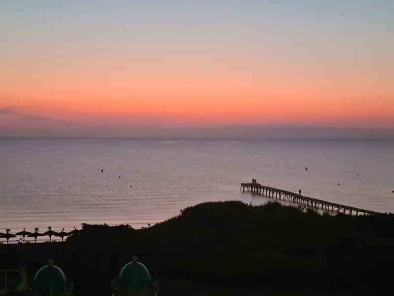 Sonnenuntergang über dem Meer mit Stegsilhouette