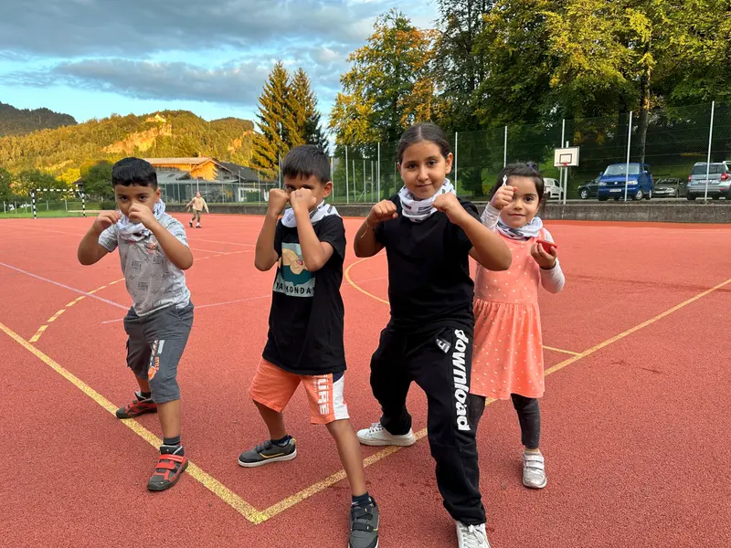 Zwei Kinder posieren mit Boxhandschuhen im Freien