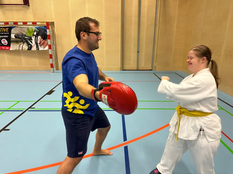 Mann hält Pratze, Person im Karategi übt Schlagtechnik