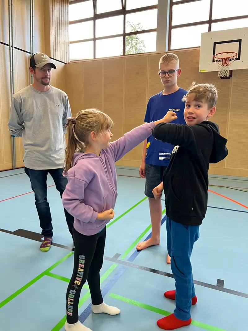 Kind schlägt spielerisch in Richtung eines anderen Kindes