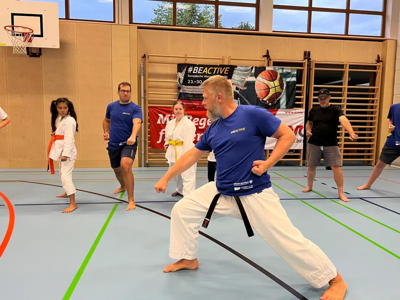 Gruppe übt gemeinsam eine Stellung in der Turnhalle