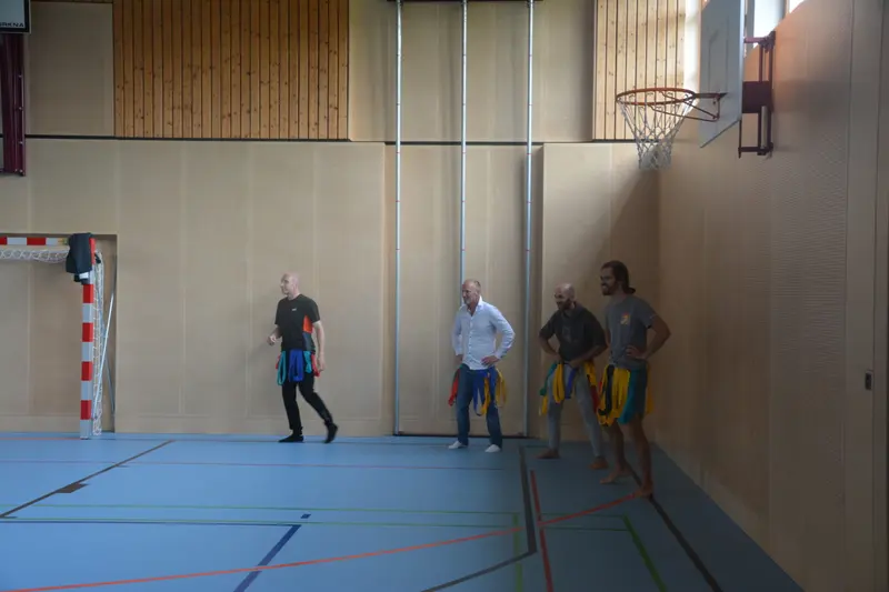 Gruppe steht an der Wand der Sporthalle