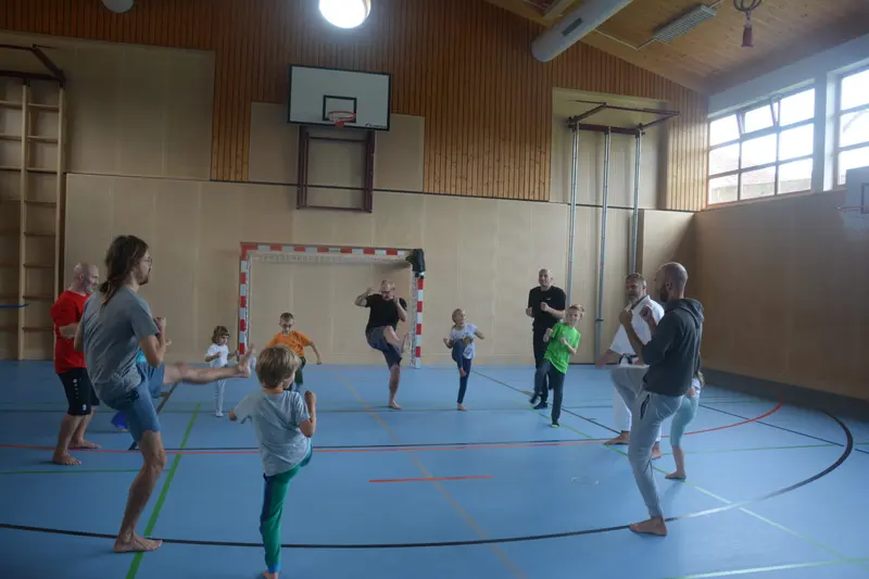 Gruppe aus Kindern und Erwachsenen spielt ein Laufspiel