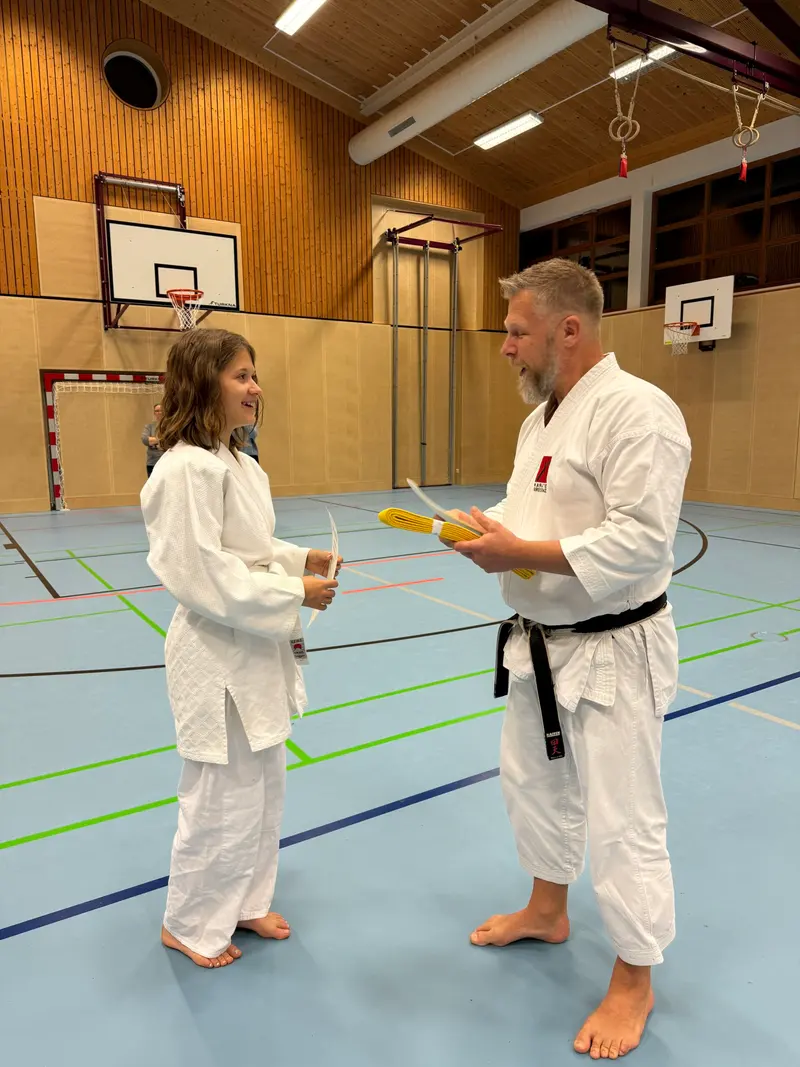 Trainer und Kind stehen sich im Karategi gegenüber