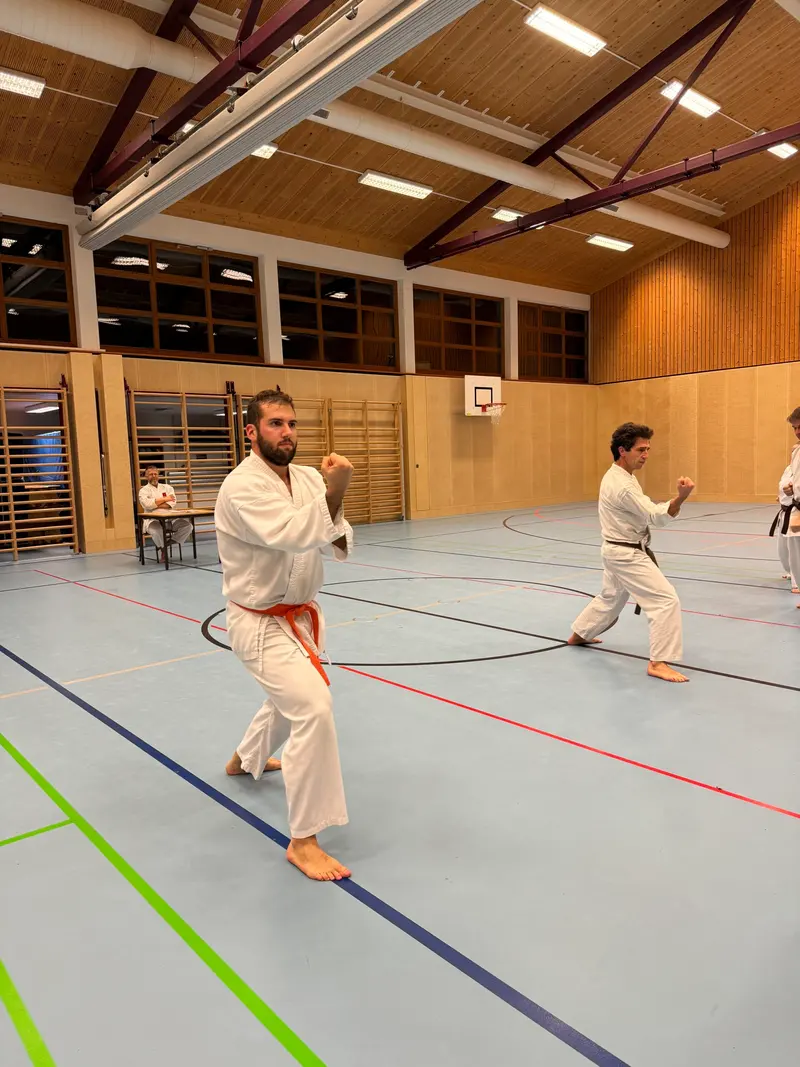 Person im Karategi steht an Tisch, blickt nach unten