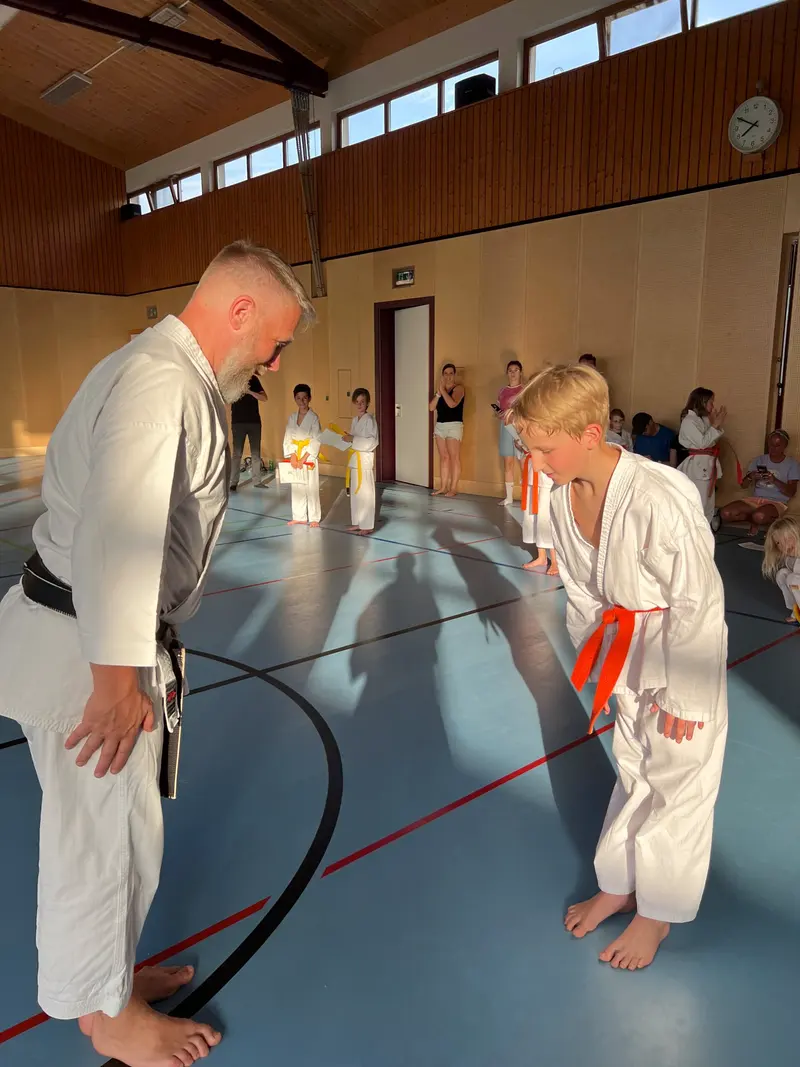 Trainer und Kind im Karategi üben Partnertechnik
